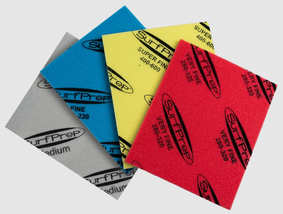 SurfPrep RAD Pads Pro foam-backed hand sanding pads in four grits — Medium (grey), Fine (blue), Super Fine (yellow), and Very Fine (red) — color-coded for easy grit identification.